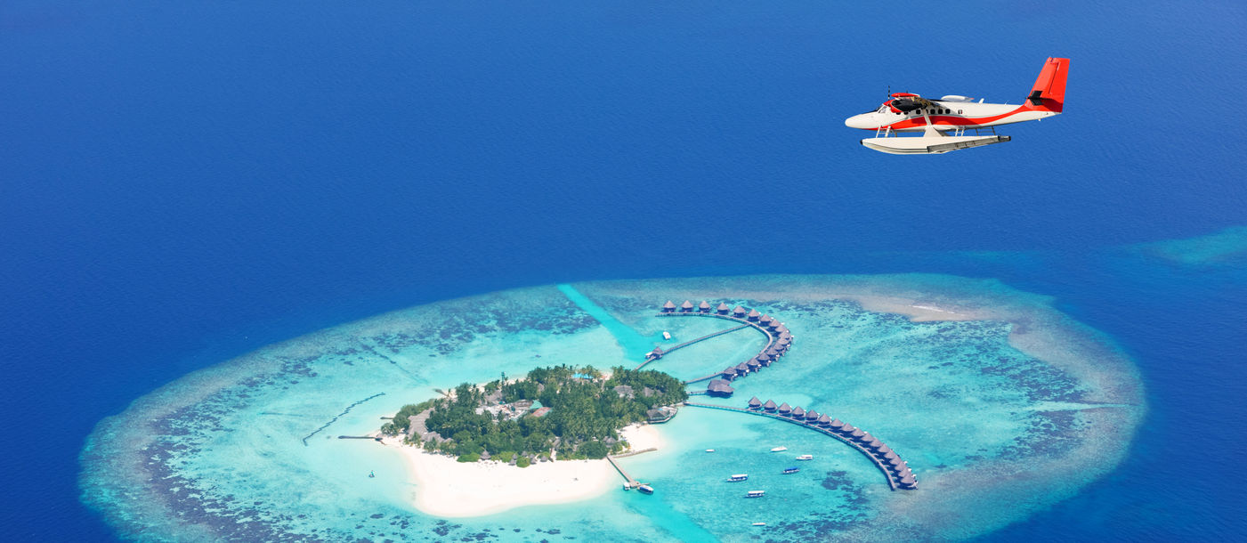 Sea plane flying above Maldives islands, Raa atol (photo via Jag_cz / iStock / Getty Images Plus)