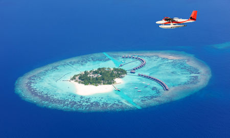 Sea plane flying above Maldives islands, Raa atol (photo via Jag_cz / iStock / Getty Images Plus)