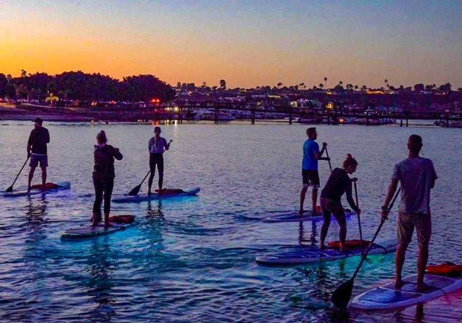 Standup paddleboarding continues to be a favorite outdoor wellness activity for groups. In Newport Beach, visitors can take part in evening Glow SUP outings on illuminated boards.
