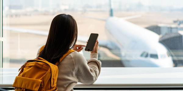 woman-using-phone-airport-soar-startup-stage