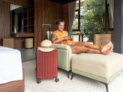 woman-relaxing-hotel-room-suitcase