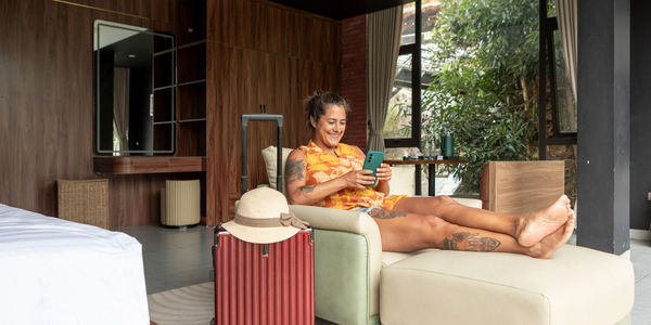 woman-relaxing-hotel-room-suitcase