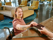 woman-wheelchair-checking-in-hotel-fora-accessibility