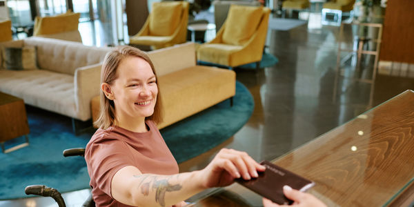 woman-wheelchair-checking-in-hotel-fora-accessibility