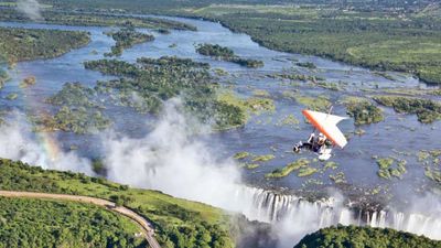 A microlight rider glides over Victoria Falls in Zambia // © 2013 The Royal Livingstone 3