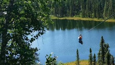 A zipliner zooms across the pond on the course's last and longest zipline at 600 feet. // © 2017 Denali Zipline Tours