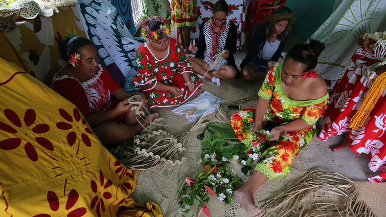 Local women demonstrate how to create flower crowns, mats and other traditional crafts.