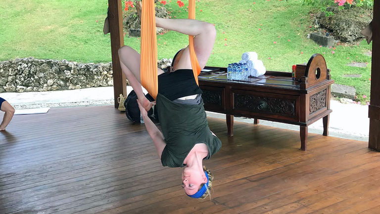 The writer practicing AntiGravity Yoga, which offers many health benefits.