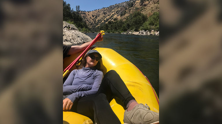 The writer takes a break from paddling the whitewater rapids to soak in some sunshine.