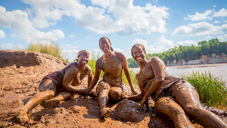 After rafting the tidal bore, there is an option to slide down the muddy banks of the river.