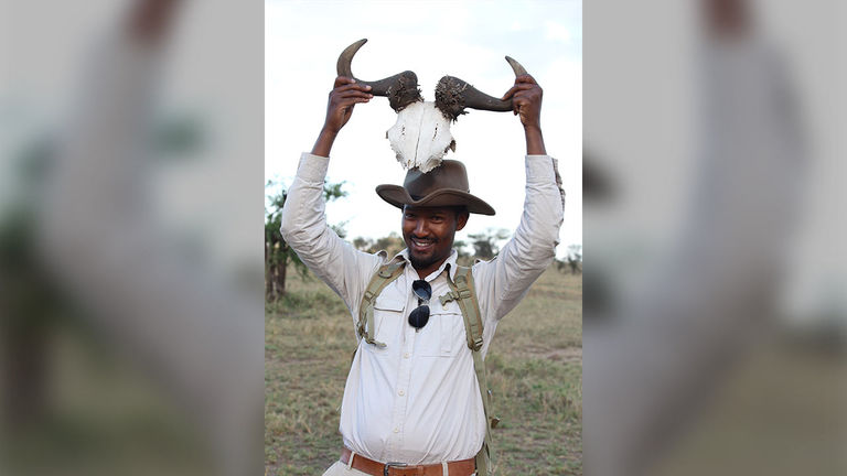 Four Seasons guide Isack holds up a hartebeest carcass and explains its uses.