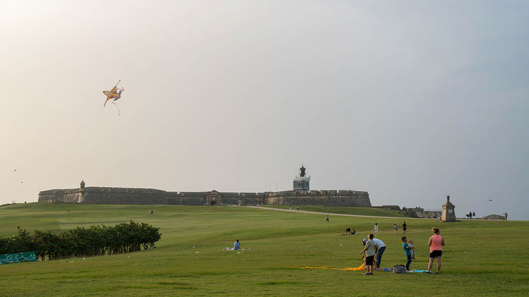 Local families flying kites in front of El Morro