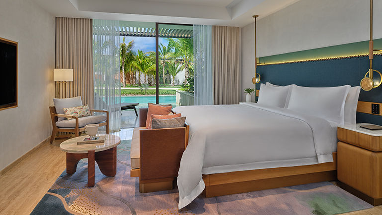 Guestroom design elements include blond woods, polished marble surfaces and turquoise accents.
