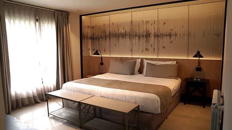 New design features of the guestrooms include wood with contemporary micro-ribbing (behind the bed), locally inspired linens and warm lighting.