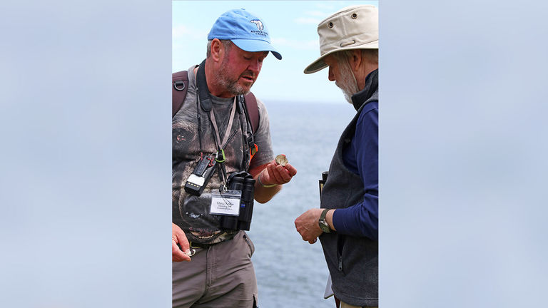 Ornithologist and conservationist Chris Rollie shares his finding — a bird egg — with a guest on the Scotland Slowly itinerary.