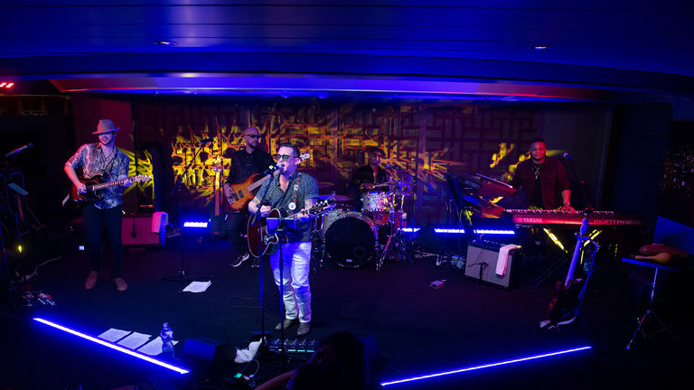 In Rolling Stone Rock Room, a live band performs top songs.