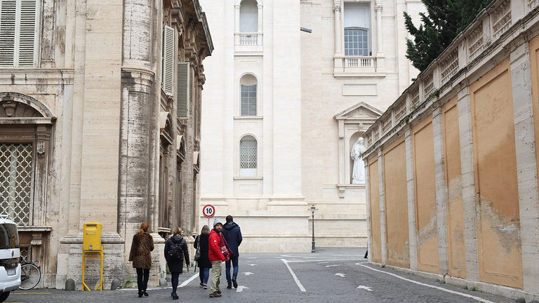 A guide walks Access Italy guests through the Vatican’s empty streets while tourists wait in line nearby.