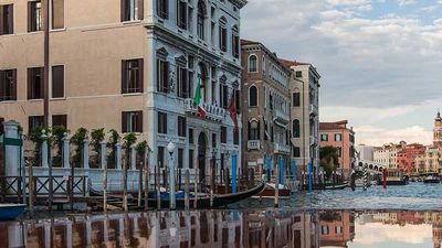 The Grand Canal is reflected in the bow of a sleek motor yacht as it carries guests to Aman Venice (left). // © 2016 Aman Venice