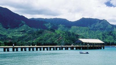 Hanalei Bay and its pier provide a picturesque gathering place for beach and ocean activities. // © 2014 HTA/Robert Coello