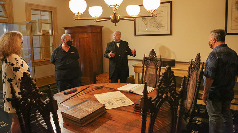 Volunteer docent Hardy Spoehr (in period costume) describes the furniture and artifacts in the chamberlain’s office during the Chamberlain’s Tour.