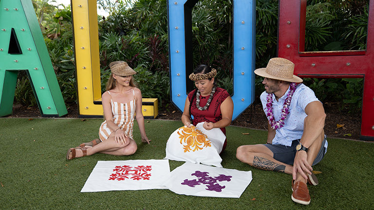 Lyndra Okamoto demonstrates how to hand-stitch patterns on cloth during the Malama Hawaiian Quilting Experience.