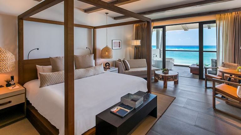 An Alcoba Ocean Front guestroom features a balcony with a hydro spa tub and a lounging area.