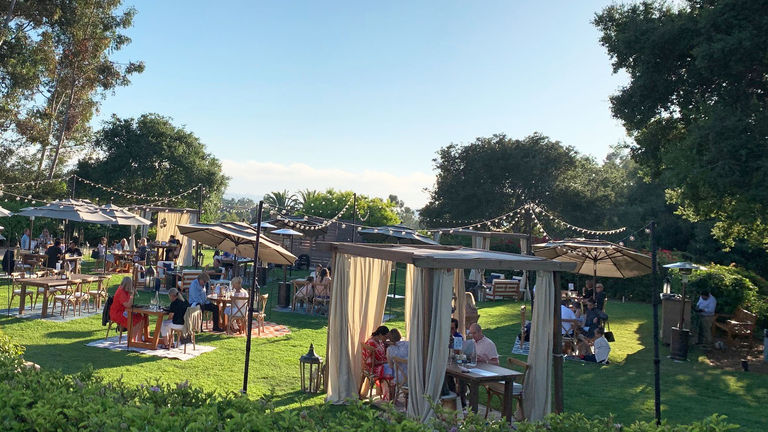 Rancho Valencia is serving dinner on its croquet lawn, where seating is safely and comfortable spaced out.