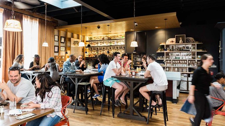 The restaurant has a speakeasy-style interior and features vintage artwork on the walls.