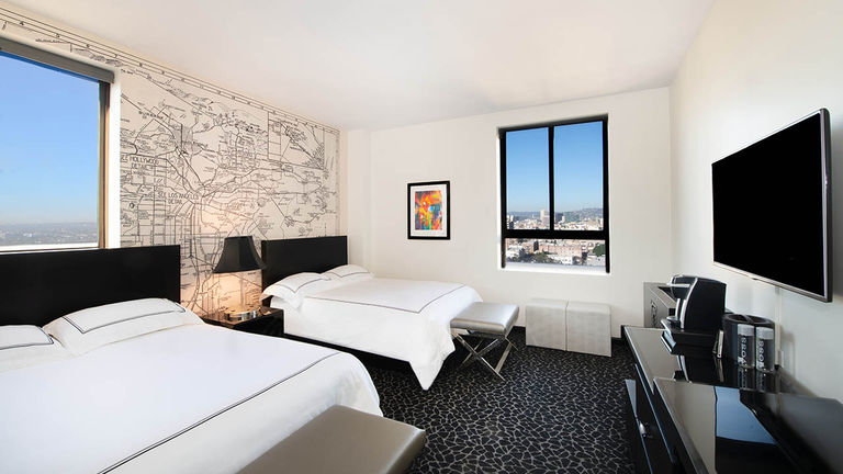 A guestroom with a vintage map of Los Angeles on the headboard wall