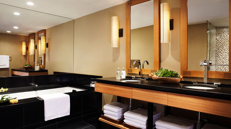 The large bathroom in a one-bedroom suite offers a soaking tub and his-and-hers vanity sinks.