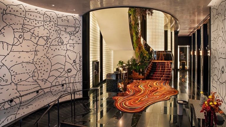 The mirrored stairway from the reception area features a colorful, Salvador Dali-esque “melting” carpet.