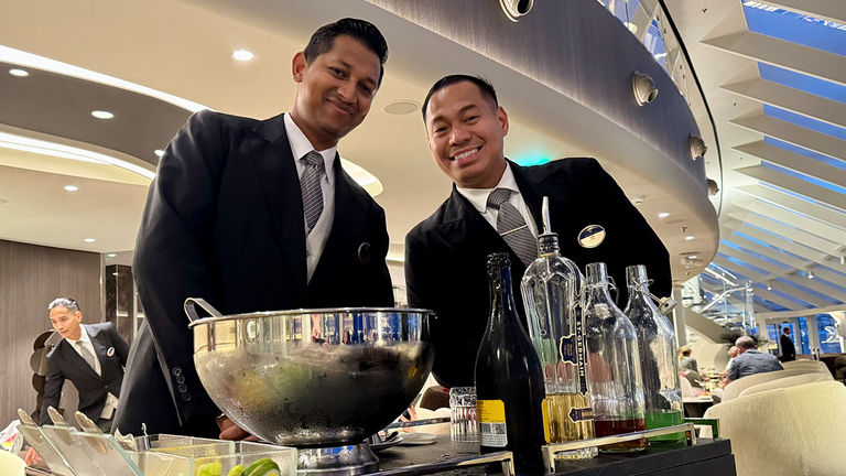 Butlers mix cocktails in the Top Sail Lounge.