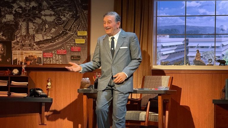 Walt casually leans against the desk in his office at Walt Disney Studios just like he did on TV.