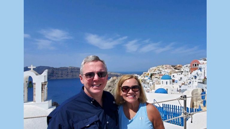 The couple, pictured here in Santorini, specialize in selling cruises.