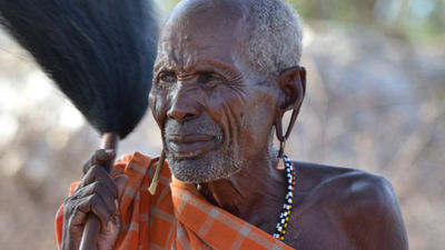 On an Abercrombie & Kent safari in Africa, a Samburu elder welcomes the tour group to his village. // © 2015 Mindy Poder