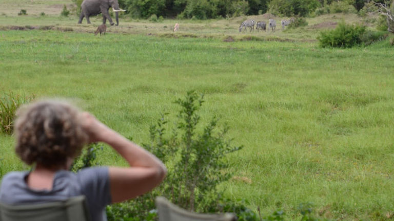 An A&K guest watches the wildlife at Governors’ Camp in Masai Mara National Reserve. // © 2015 Africas Best Photos