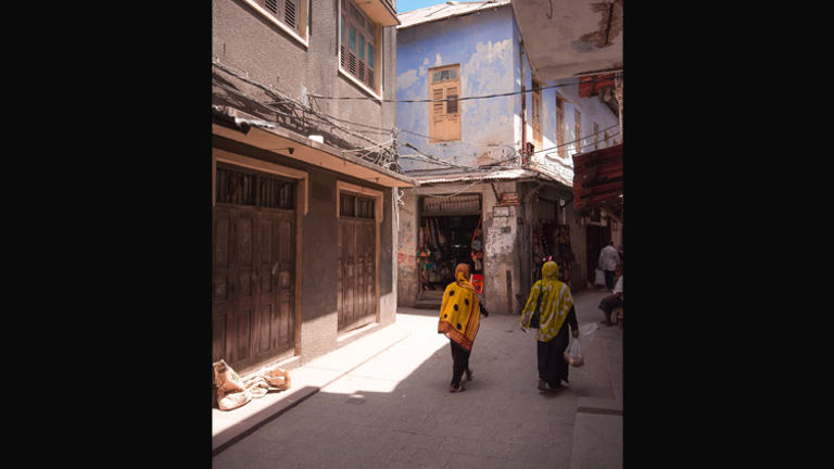 Women walk through Stone Town's narrow streets. // (c) 2013 Bob Demyan