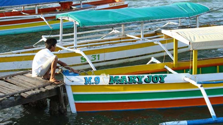 A bangka boat owner secures his boat at Lucas Wharf, the gateway to Hundred Islands. // (c) 2013 Nila Do