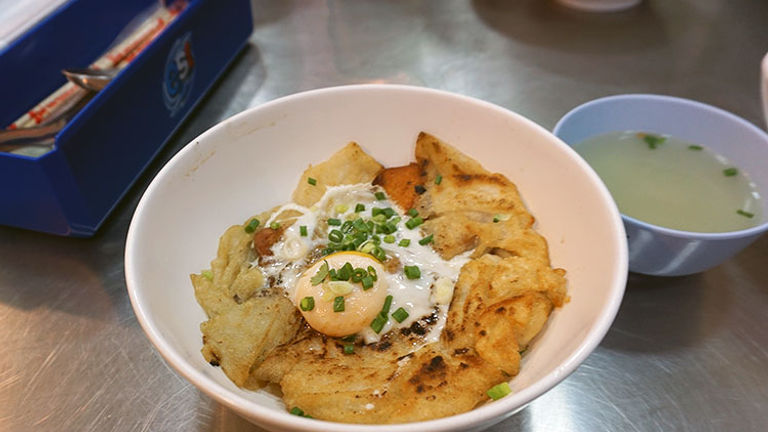 These crispy-yet-sticky rice noodles — topped with a runny egg and fixings such as scallions, chicken and more — are a popular, inexpensive dish. // © 2017 Valerie Chen