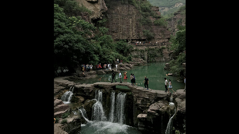 Visitors can cross over the seafoam-green water on bridges cut into the stone. // © Michelle Juergen