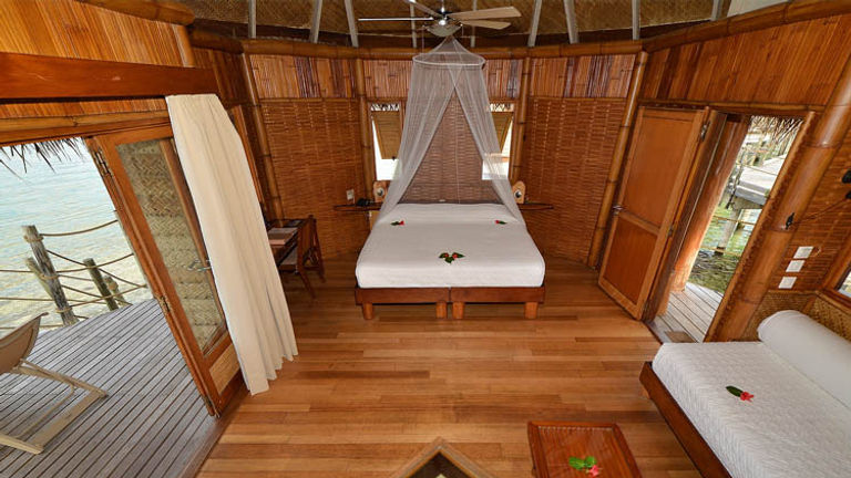 Rooms feature Polynesian products such as teak wood and coconut palm-thatched roofing. // © 2017 Tikehau Pearl Beach Resort