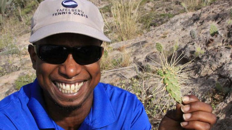 One of the resort’s recreation agents, Maurice Wright, displays an example of the island’s native prickly pear cacti. // © 2014 Cody Geib