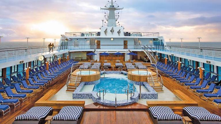 After: The pool area now boasts striking white and blue mosaic tile designs, new lounge furniture and a golden teak deck. // © 2014 Oceania Cruises
