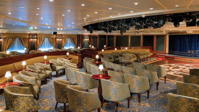 The new theater lounge offers a fresh auditorium-style seating arrangement, and the former purple and gold theme has given way to a lighter aqua and gold motif. // © 2014 Oceania Cruises