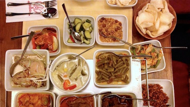 Translated as “rice table,” rijsttafel is collection of small plates and snacks — ranging from meat skewers to nuts and pickles — that surround a bowl of rice. // © 2014 David Wade