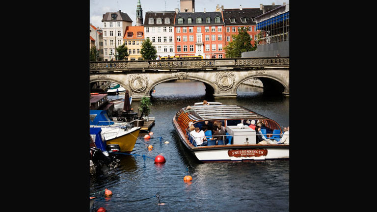A boat tour is another great way to explore Copenhagen, which is crisscrossed with many canals and elegant bridges, such as the one that stretches over Frederiksholm Canal. // © 2014 Ty Stange