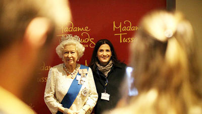 A guest of ExploreGB, VisitBritain’s new flagship event, poses with a wax representation of Queen Elizabeth II. // © 2015 VisitBritain