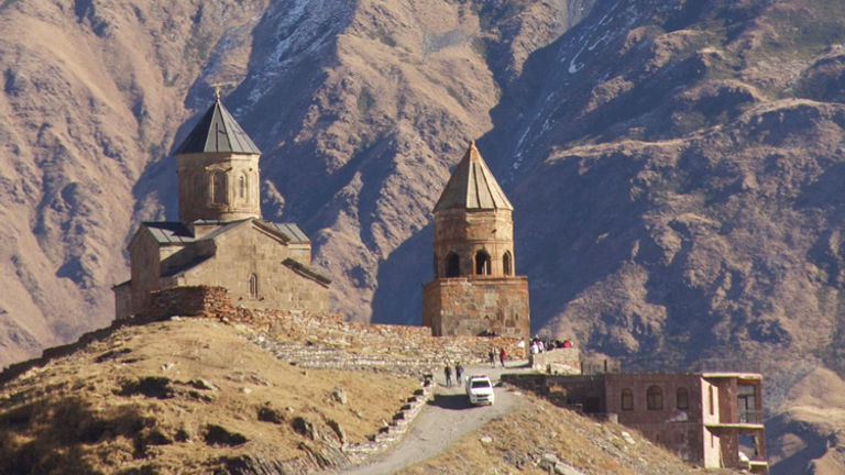 Mount Kazbegi looms over the 14th-century Gergeti Trinity Church in Georgia. // © 2014 Devin Galaudet