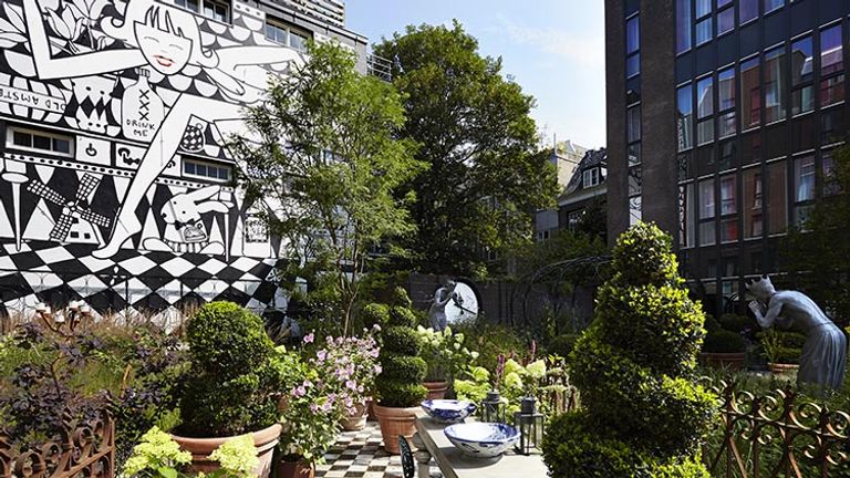 An Alice in Amsterdam mural is on display in the hotel’s private garden. // © 2016 Andaz Amsterdam, Prinsengracht