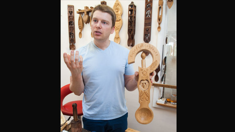 Kerry is joined by his son Dai, here shown telling the stories behind several of the family’s annual lovespoons. // © 2014 Mindy Poder